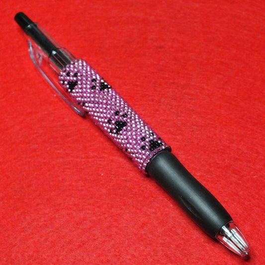 Handmade dog paw beaded pen - pink and black pawprint design.