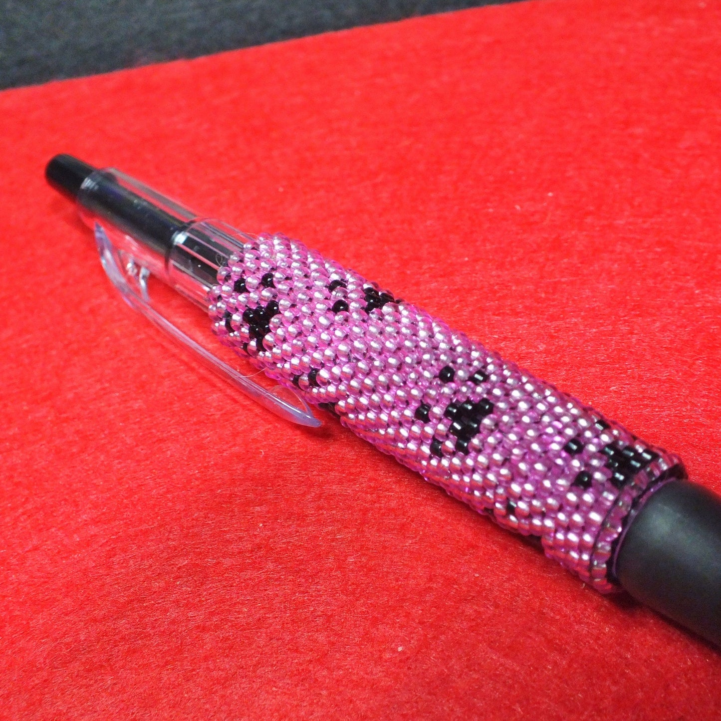 Handmade dog paw beaded pen - pink and black pawprint design.