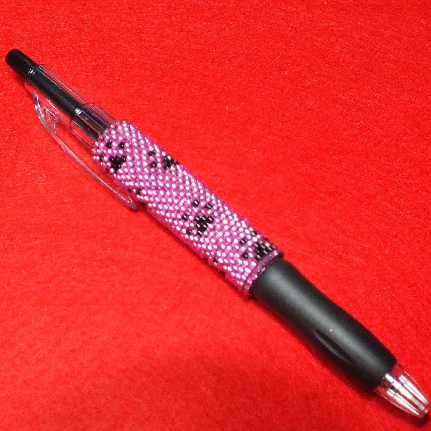 Handmade dog paw beaded pen - pink and black pawprint design.