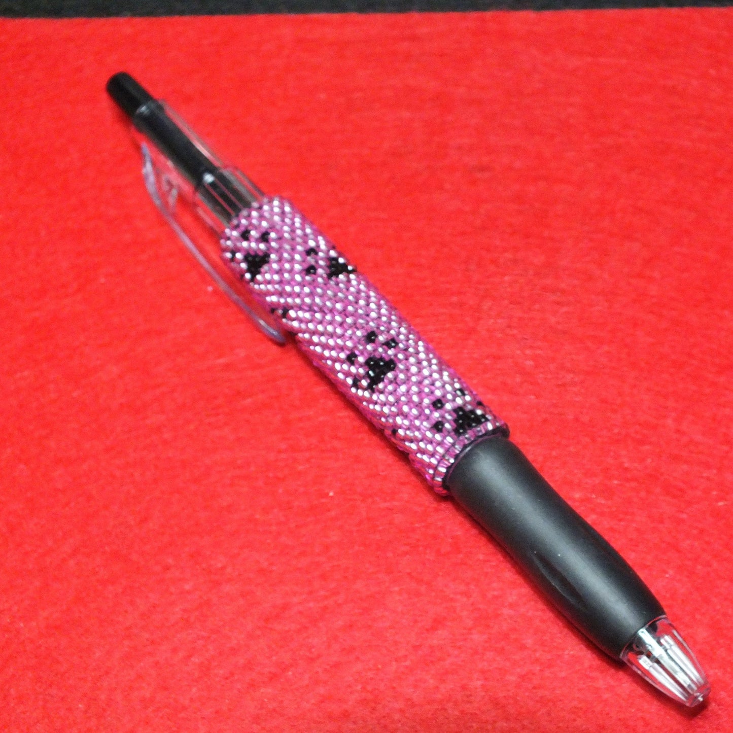 Handmade dog paw beaded pen - pink and black pawprint design.
