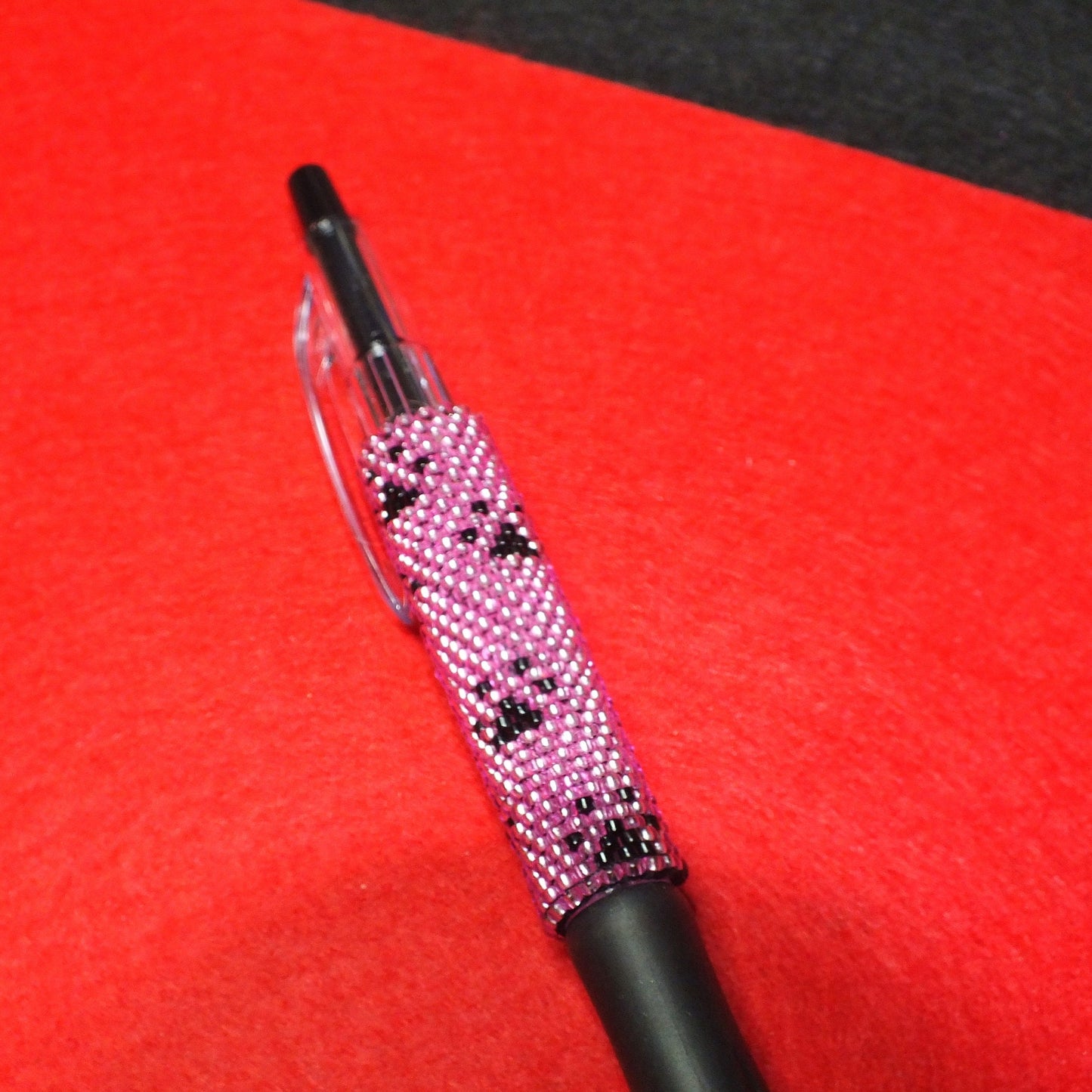 Handmade dog paw beaded pen - pink and black pawprint design.